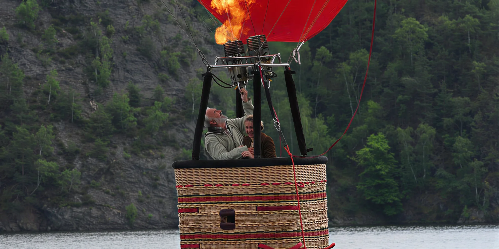 Empties — two passengers in the basket of a hot-air balloon above a river