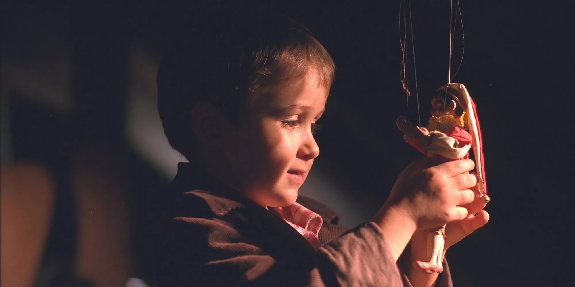 Kolya — a boy holding up a marionette